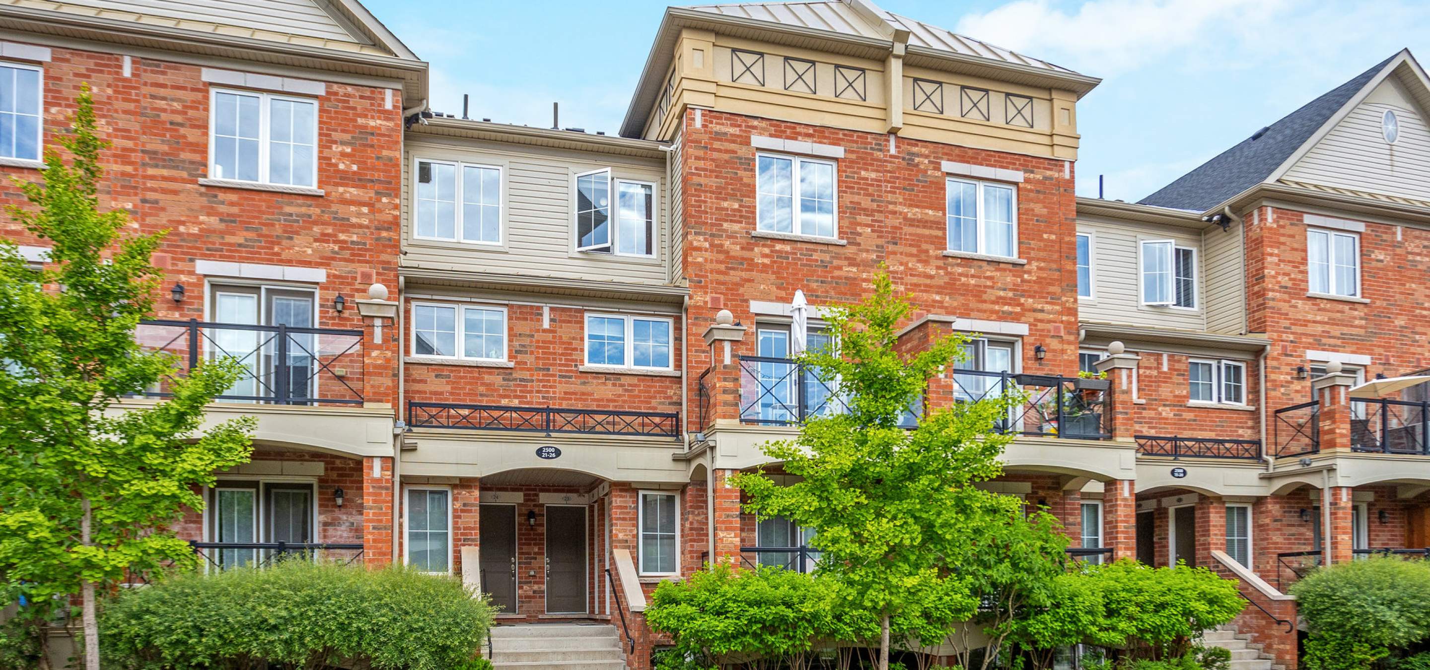 Beautiful townhome with blue skies and green trees