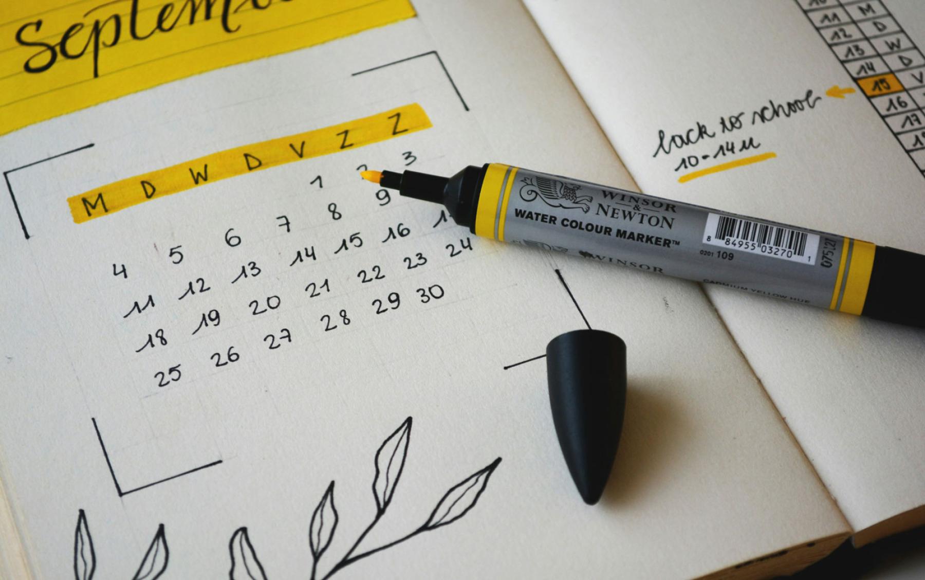 An open dayplanner with highlighter sitting open.